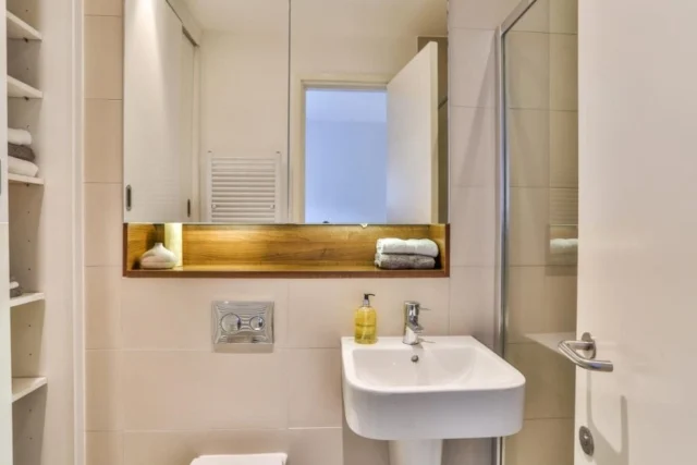 Stone-tiled bathroom renovation in a South London period property by AXE Construction
