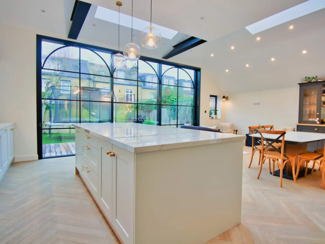 Kitchen island in front of bi-fold doors in an extended kitchen