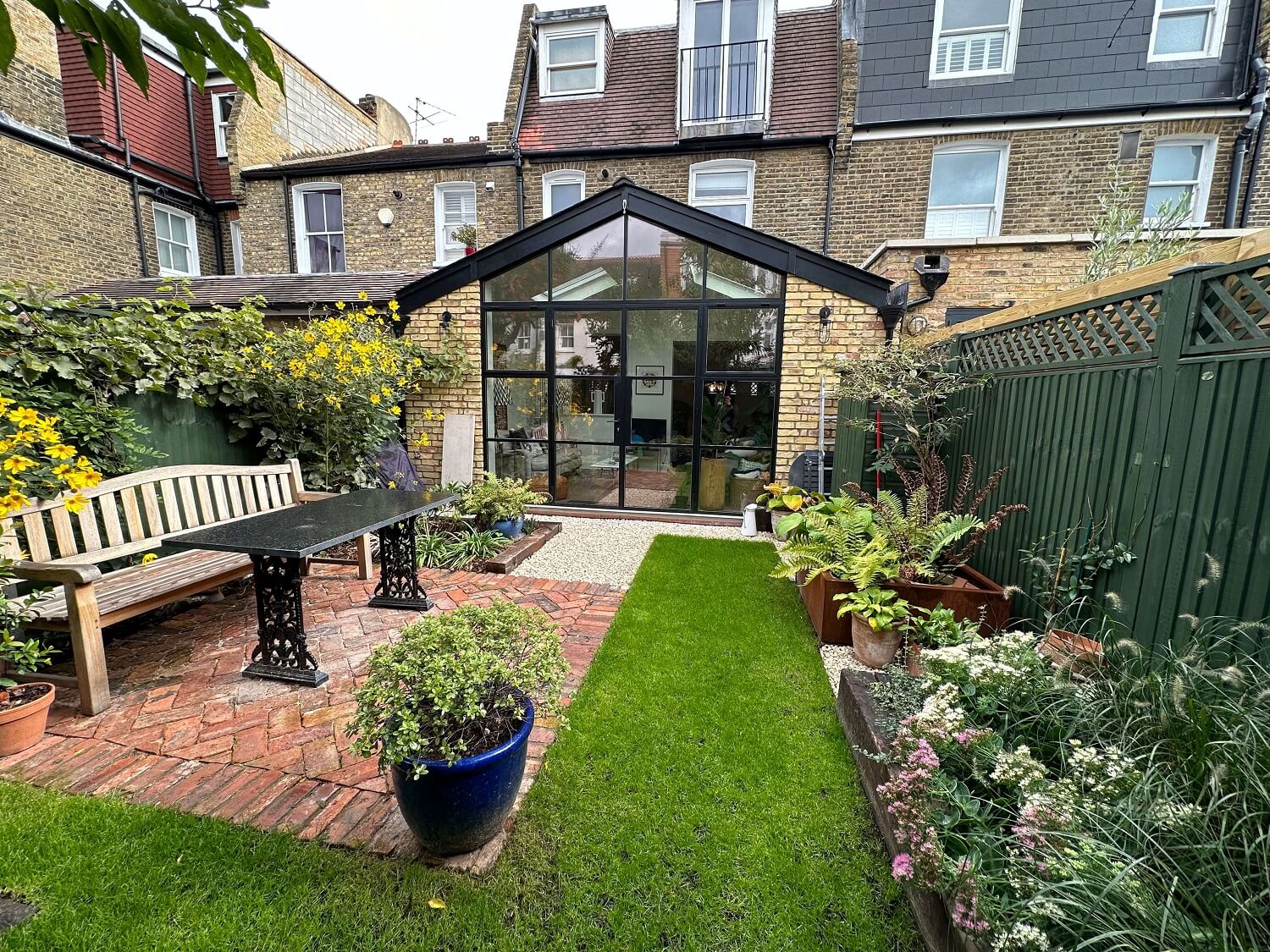 Red brick single-storey rear extension seen from the garden