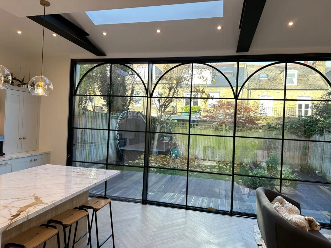 A side return rear elevation with feature steel-framed glazing — large-format glazing of this scale typically adds £8K–£18K to the project cost.